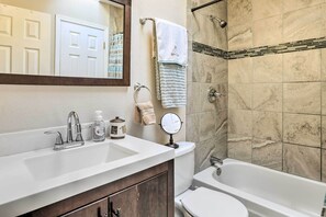 A bathroom with a white sink, a toilet, a bathtub, and a shower.