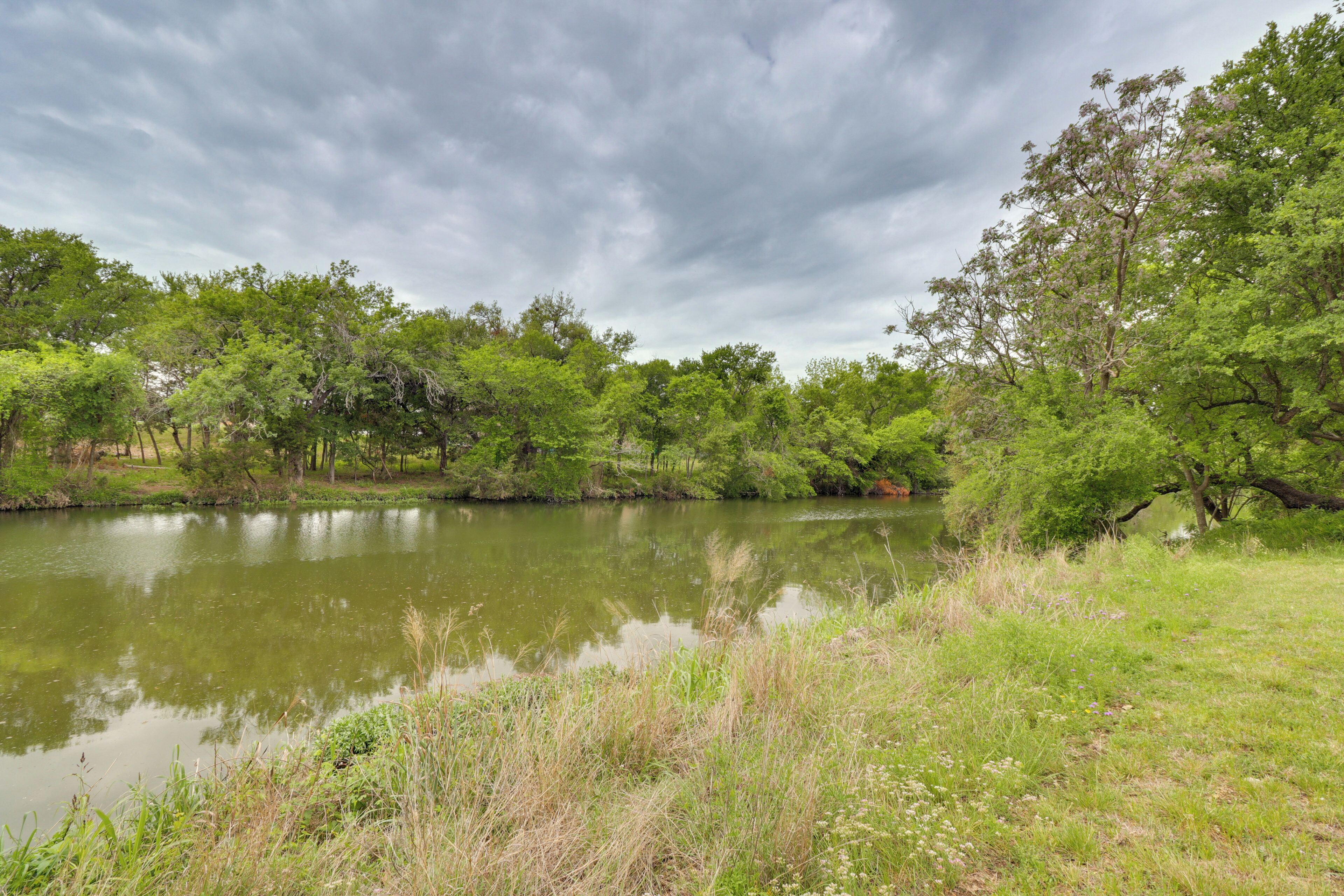 A serene lakeside landscape with dense greenery and trees.