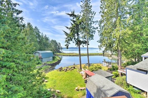 A lakeside property with a house, a dock, and a small boat.