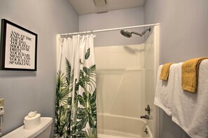 Une salle de bain avec une douche, des toilettes et une citation encadrée au mur.