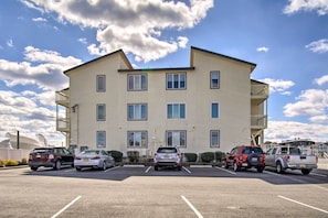 A multi-story building with a parking lot in front.