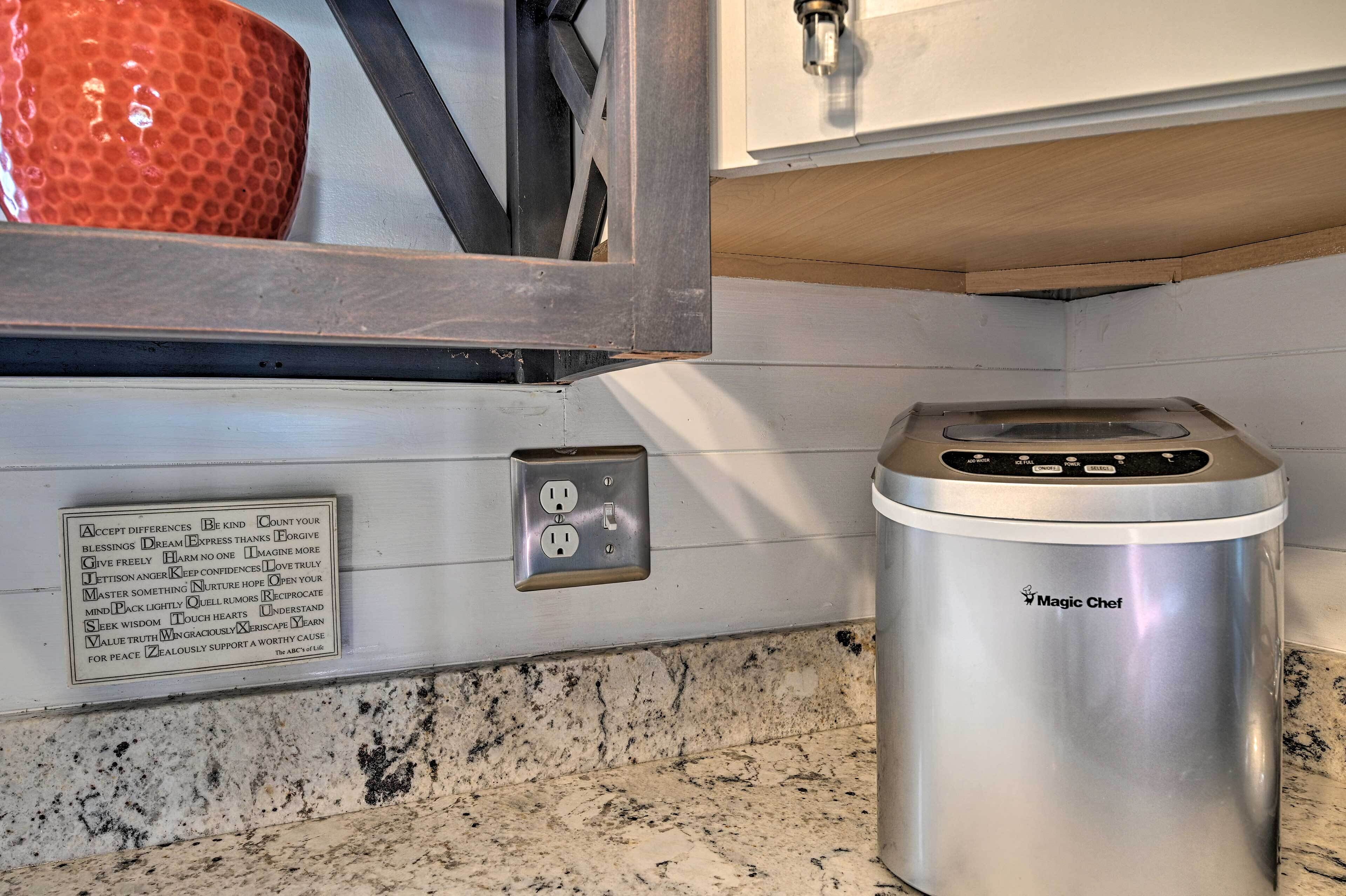 A kitchen with a stainless steel appliance, a wall-mounted electrical outlet, and a granite countertop.