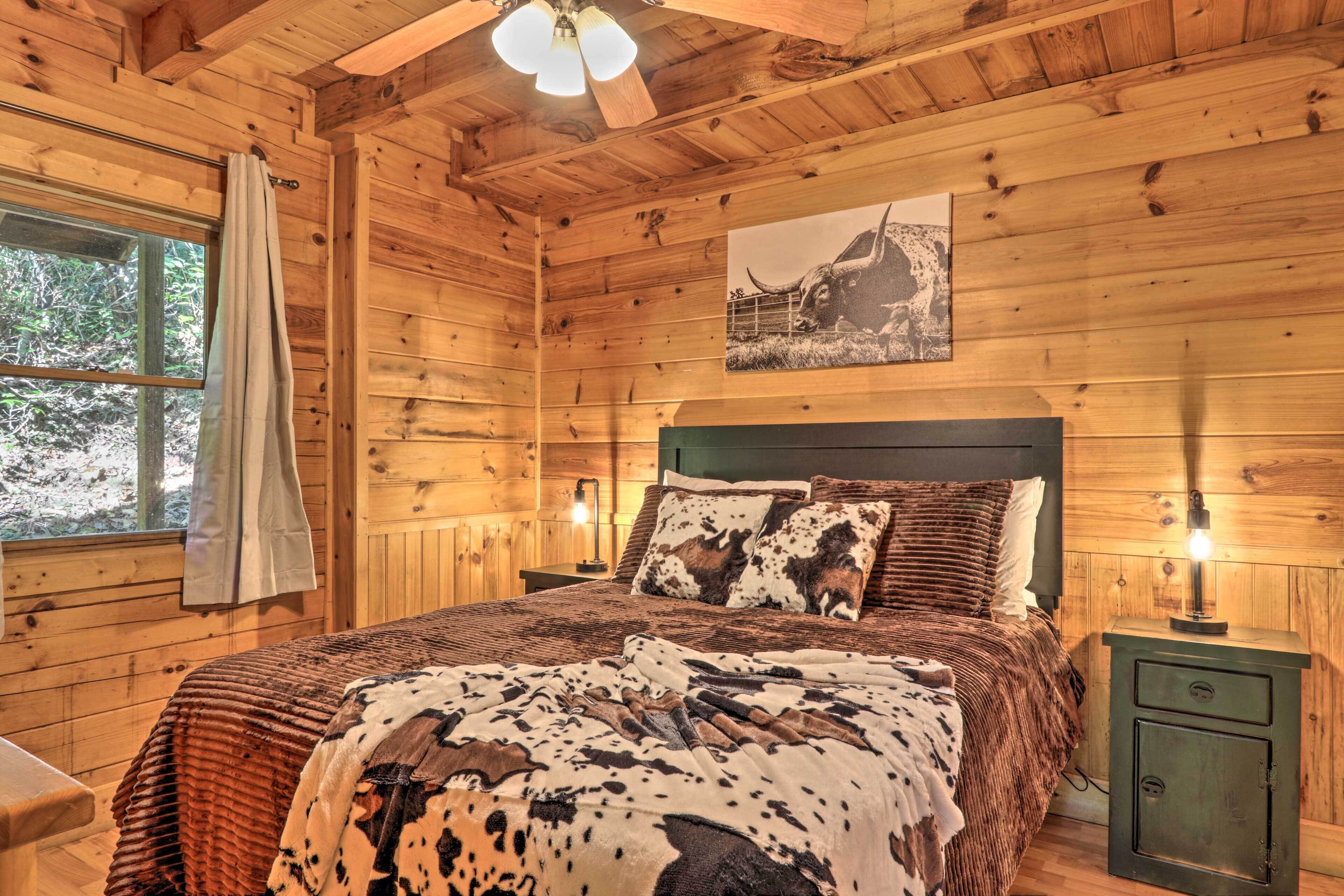 Une chambre à coucher dans une cabane en bois, avec un lit, une table de chevet, une armoire verte et une fenêtre avec des rideaux.