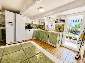 A kitchen with a refrigerator, dishwasher, and green cabinets. - the sea while the legendary country's calm (le beausset)