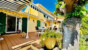 A courtyard with a wooden deck, outdoor seating, and a large planter. - the sea while the legendary country's calm (le beausset)