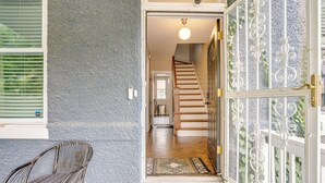 Eine Treppe führt zu einer zweiten Etage, ein Stuhl steht daneben und ein schmiedeeisernes Tor ist zu sehen.