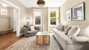 Ein Wohnzimmer mit einer Couch, einem Couchtisch und einer Stehlampe.