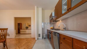Une cuisine moderne avec des meubles en bois, un évier en acier inoxydable et un sol à motifs en chevrons.