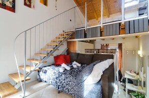 A bedroom with a bed, a staircase, a desk, and a radiator. - LOFT ATMOSPHERA TRENTOCENTRO-CIPAT022205-AT-066735 (Trento)