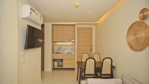 A compact living space with a kitchenette, dining area, and a sofa.
