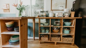 A kitchen with wooden shelves holding dishes and cookware.