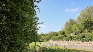 A stone wall with a grassy area and a small stream.