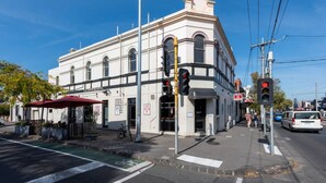 A white building with arched windows and a sign reading "Carlton Draught." - Private Unit in Heritage Building in Fitzroy North (Fitzroy North)