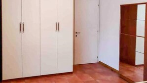 Une pièce dotée d’une grande armoire, d’une porte et d’un coin orné d’un panneau en bois.