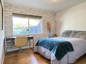 A bedroom with a bed, a desk, and a chair. - Mid Century View Home in Calabasas (Calabasas)