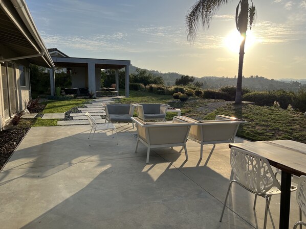 A patio area with outdoor furniture, a covered seating area, and a view of a hilly landscape. - Mid Century View Home in Calabasas (Calabasas)