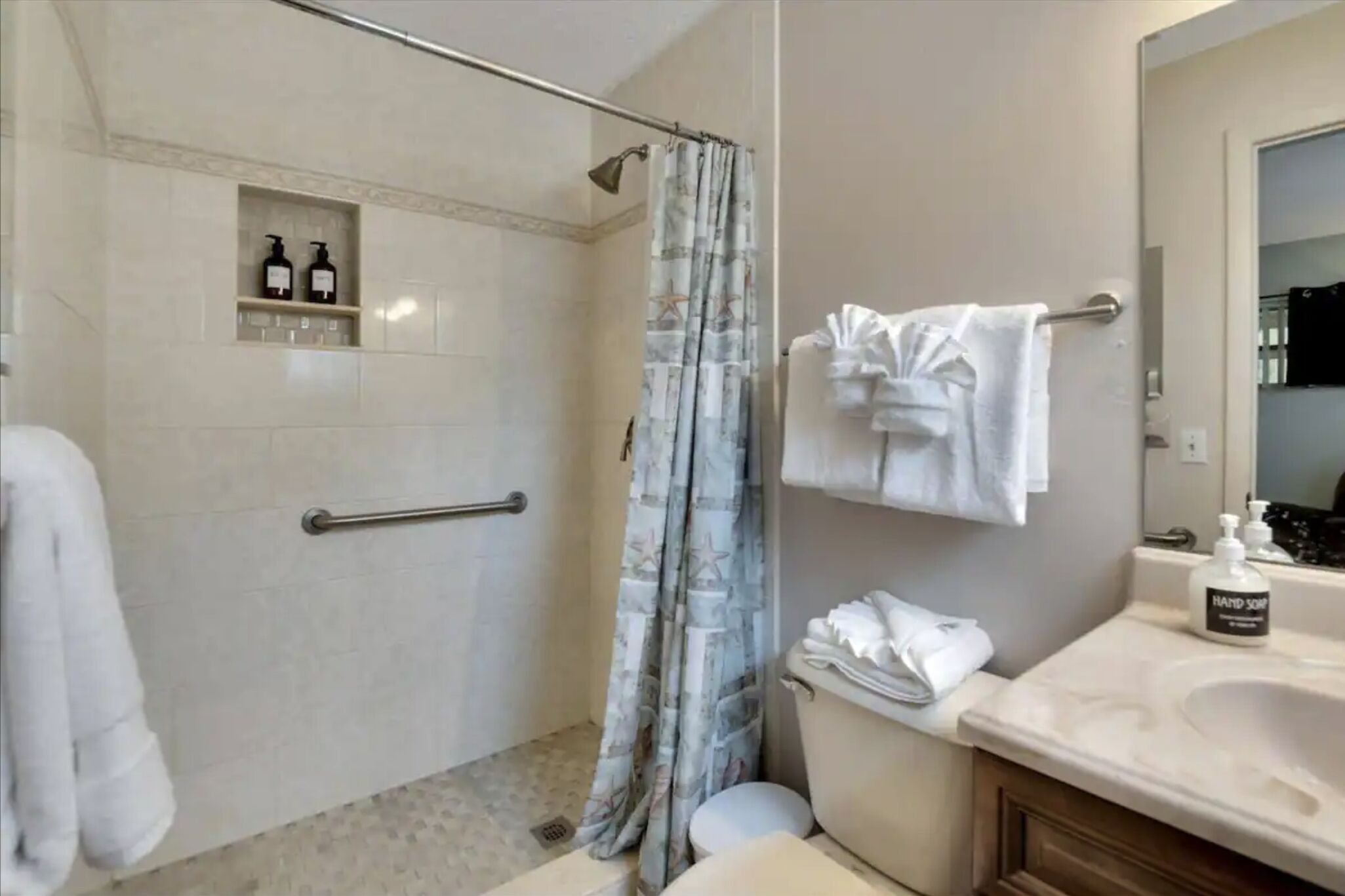 Ein Badezimmer mit Dusche, Toilette, Waschbecken und Handtuchhalter.