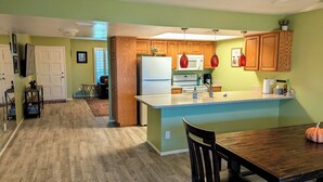 A modern kitchen with wooden cabinets, a white refrigerator, and a central island with a sink.