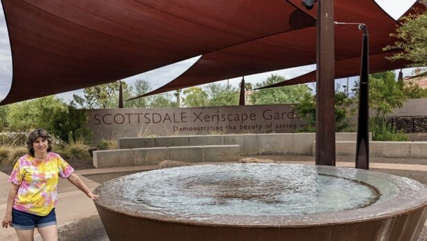 A large circular water feature in a park with a sign reading "SCOTTSDALE Xeriscape Garden."