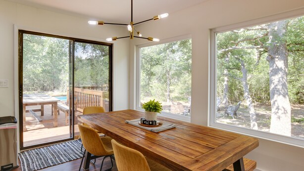 Un coin repas avec une table en bois, deux chaises jaunes et une plante en pot.