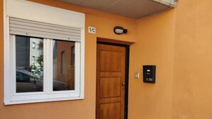Una puerta con una placa que indica '1/C' y un teclado de seguridad en la pared.