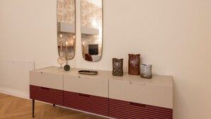 A modern interior with a white console table, two mirrors, and decorative items. - Apartments Florence - Buontalenti Exclusive (Firenze)