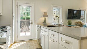 A modern kitchen with white cabinets, a built-in oven, and a large window. - Beautiful Raleigh Cottage Rental: 5 Mi to Downtown (Raleigh)