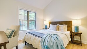 A bedroom with a large bed, two bedside tables, a chair, and a window. - Beautiful Raleigh Cottage Rental: 5 Mi to Downtown (Raleigh)
