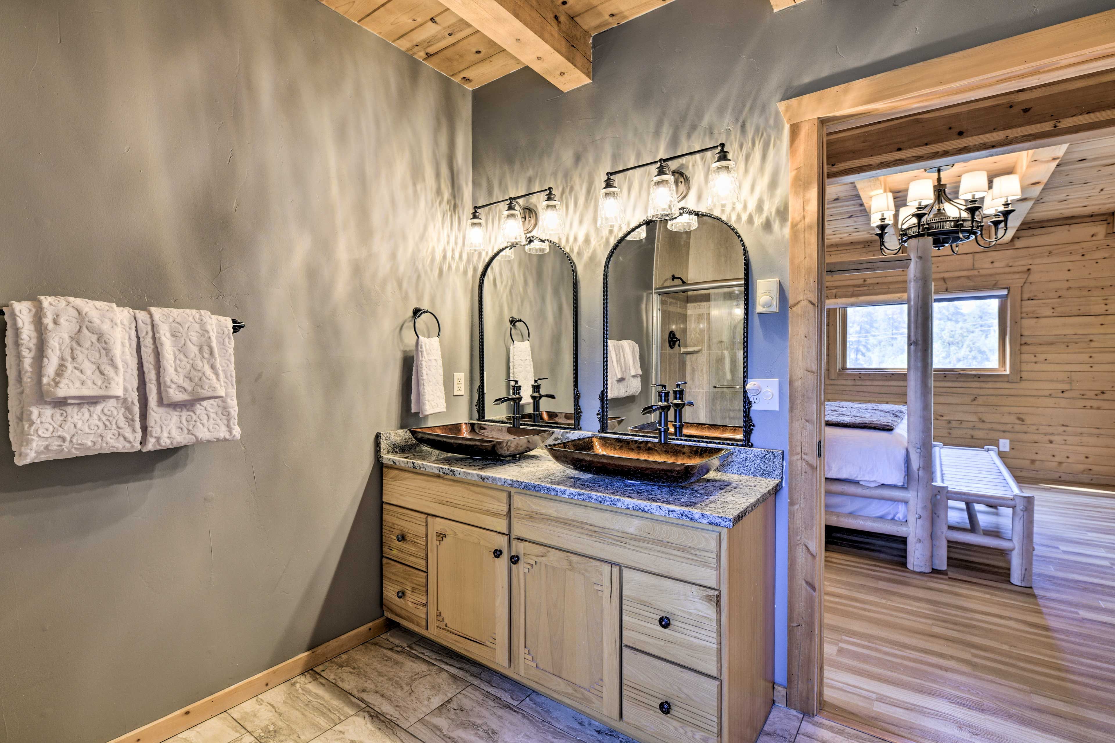 A bathroom with two sinks, wooden cabinets, and a large mirror.