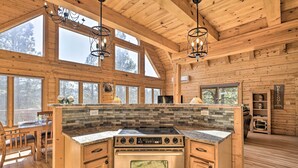 A spacious kitchen with a large island, wooden cabinetry, and a stone backsplash. - Lazy Beaver Lodge Pagosa Cabin w/ Deck, Fire Pit (Pagosa Springs)