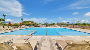 A large outdoor swimming pool with lounge chairs and umbrellas, surrounded by palm trees and a wooden deck. - Island Oasis Near Kaanapali Beach & Black Rock (Kaanapali)
