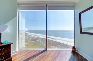 Enjoy the ocean view from the balcony, featuring a sliding glass door and a comfortable seating area.