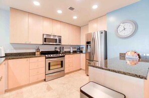 Fully equipped kitchen with microwave, oven, and refrigerator.