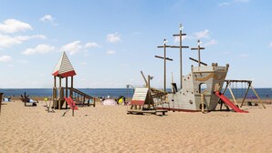 A beach with a wooden play structure and a lifeguard tower. - Lovely apartment in Oostende with WiFi (Oostende)