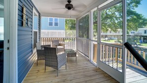 A covered porch with wicker furniture, a ceiling fan, and large windows offering a view of the neighborhood. - Charleston Home w/ Porch - 3 Mi to Folly Beach! (Charleston)