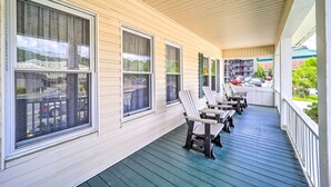 Eine überdachte Veranda mit mehreren Fenstern und Sitzgelegenheiten im Freien.