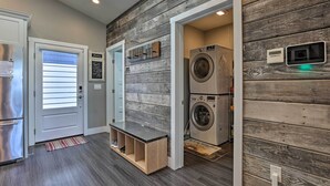 A laundry room with a washing machine and dryer, a bench, and a door with a window. - Sierra Sunset Inn - 3 Miles to Placerville! (Diamond Springs)