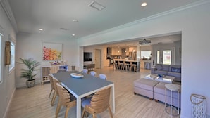 Un espacio habitable amplio con una mesa de comedor, sofá y una cocina al fondo.