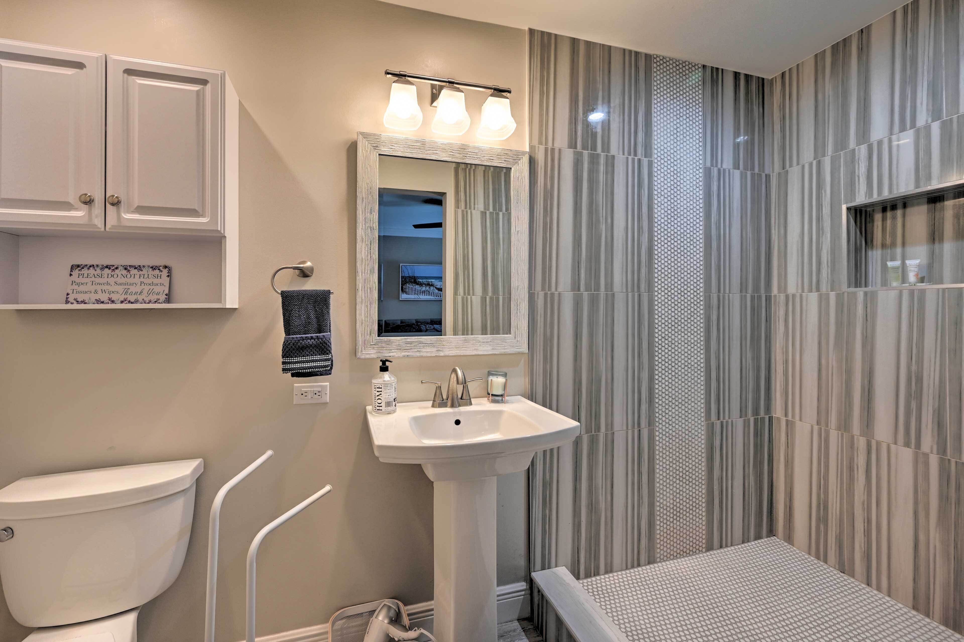 A bathroom with a white sink, a toilet, and a shower area.