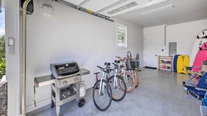 A garage with bicycles, a grill, and a storage area. - Spacious Kauai Getaway < 1 Mi to the Ocean! (Princeville)