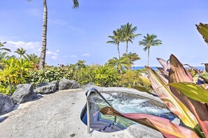 A hot tub with a clear view of the ocean, surrounded by tropical plants and palm trees. - Sun-soaked Waikoloa Retreat w/ Private Lanai! (Waikoloa)