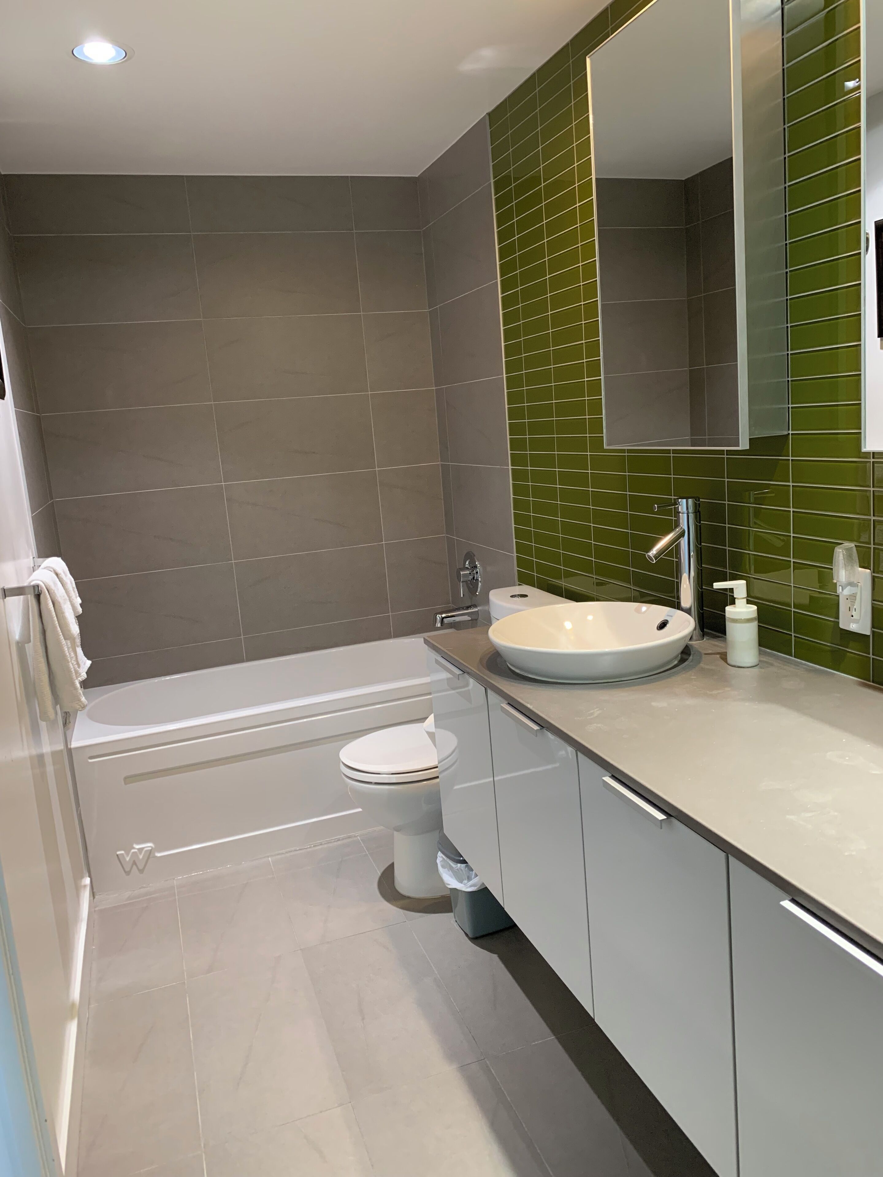 Ein modernes Badezimmer mit Badewanne, Toilette und Waschbecken.