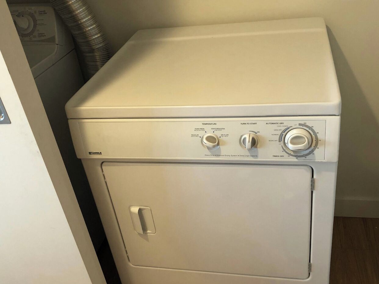 A compact, white front-loading washing machine with a control panel featuring temperature settings, a start button, and a timed dry function.