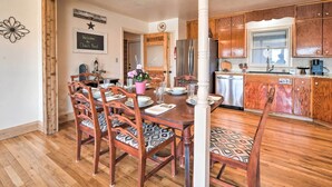 A dining area with wooden chairs and a table set for four. A wooden column is in the foreground. - 1 Mi to Dtwn Fredericksburg: Quiet Getaway w/ Yard (Fredericksburg)