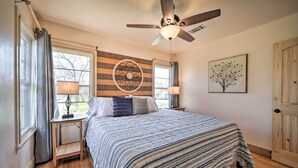 A bedroom with a bed, a ceiling fan, a wall clock, and a window with curtains. - 1 Mi to Dtwn Fredericksburg: Quiet Getaway w/ Yard (Fredericksburg)