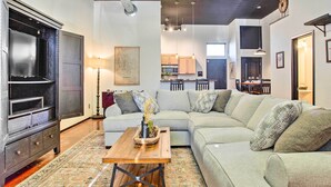 A living room with a sectional sofa, a wooden coffee table, and a dark entertainment unit. - Norman, Oklahoma, Vacation Rental 1 Mi to OU! (Norman)