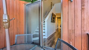 Un patio con puerta corrediza de vidrio que da a una escalera y un pasillo.