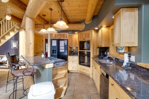 Kitchen with central island, sink, and stove, featuring cabinets and a countertop.