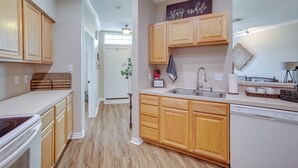 A kitchen with wooden cabinets, a dishwasher, and a countertop with a sink.