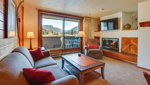 A living room with a sofa, armchair, coffee table, and fireplace. - 1 Mi to Keystone Ski Lift: Lakefront 4-season Gem (Keystone)